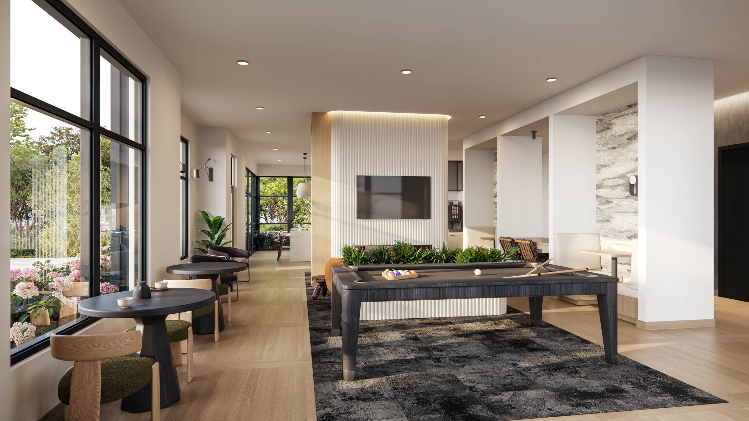 Royce Townhomes Modern lounge with pool table, TV, seating areas, large windows, plants, and light wood flooring.