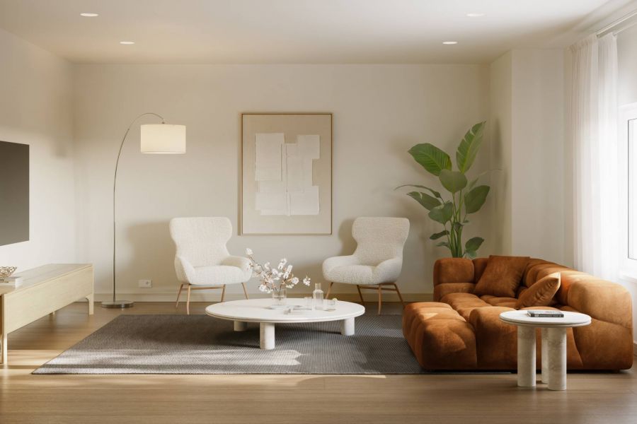 Royce Townhomes Modern living room with a rust sofa, two white chairs, round coffee table, and a large plant by the window.